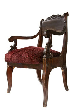 Кресло с резными деревянными подлокотниками.