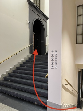 Поднимитесь по лестнице и войдите в дверь слева