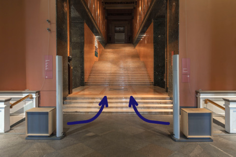 Please go up the side stairs to the space right in front of the Museum's Rose Staircase